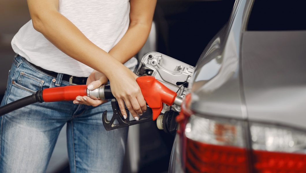 Terugkeer van rode diesel. Persoon tankt met rode slang.